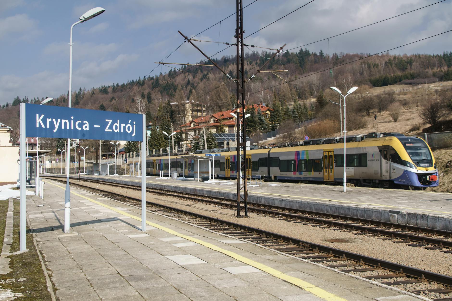 Ilustracja przedstawiająca smartfon z aplikacją do parkowania i mapę Żywca w tle, symbolizującą nowe udogodnienia transportowe.